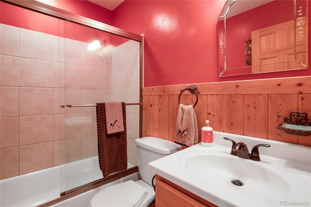 full bathroom featuring vanity, toilet, and bath / shower combo with glass door