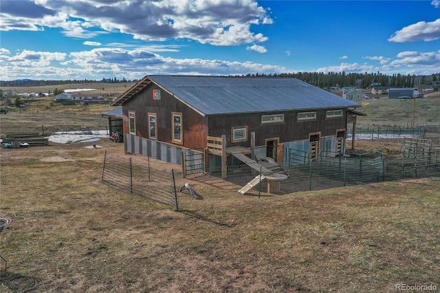 rear view of property featuring an outbuilding and a rural view