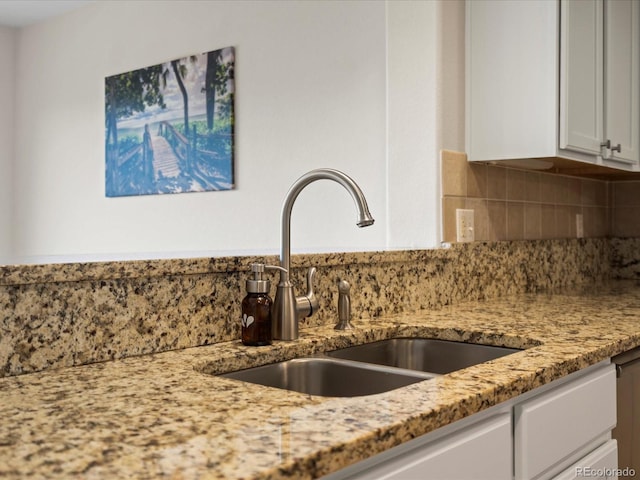 7400 W Grant Ranch Blvd Unit 19, Littleton, CO 80123 - kitchen view of a sink, tasteful backsplash, white cabinetry, and light stone countertops
