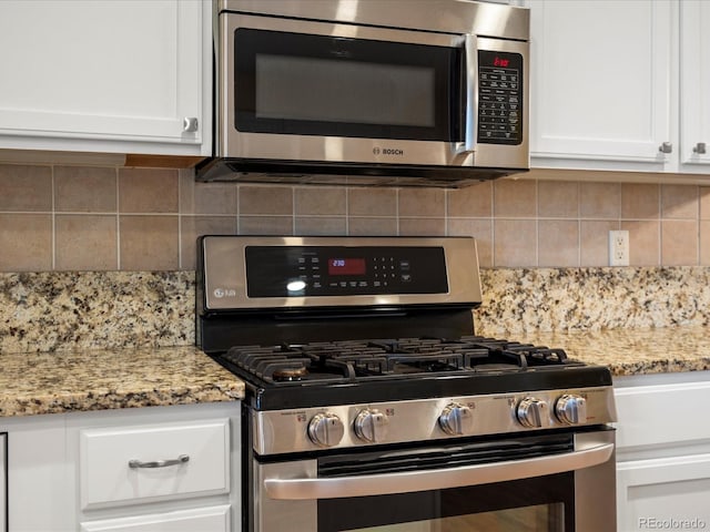 7400 W Grant Ranch Blvd Unit 19, Littleton, CO 80123 - kitchen featuring stainless steel appliances, white cabinetry, decorative backsplash, and light stone counters