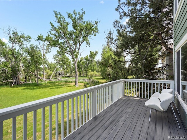 7400 W Grant Ranch Blvd Unit 19, Littleton, CO 80123 - deck featuring a lawn and view of wooded area