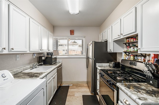 kitchen featuring washer / dryer, stainless steel appliances, white cabinetry, and sink