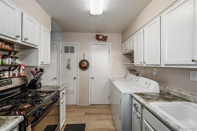 laundry area featuring light hardwood / wood-style flooring, independent washer and dryer, and sink