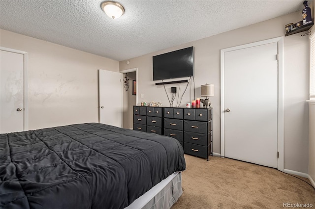 bedroom featuring a textured ceiling and light colored carpet