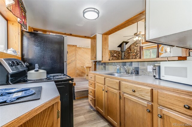 kitchen featuring tasteful backsplash, ceiling fan, sink, light wood-type flooring, and stainless steel appliances