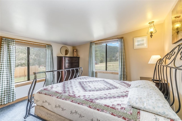 carpeted bedroom featuring multiple windows and lofted ceiling