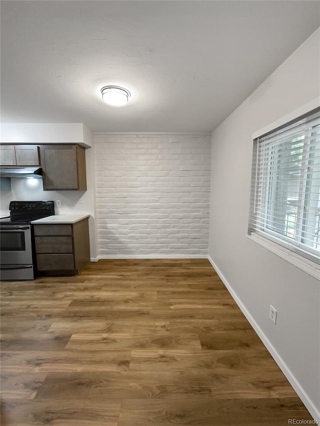 kitchen featuring dark wood-type flooring, stainless steel electric stove, and dark brown cabinets