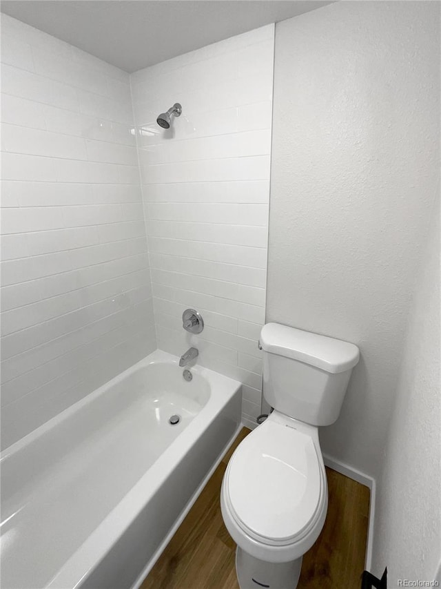 bathroom with toilet, wood-type flooring, and shower / tub combination