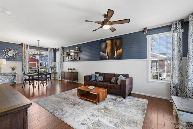living room with a ceiling fan, a chandelier, hardwood / wood-style floors, and baseboards