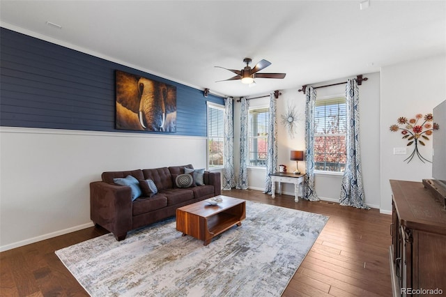 living area with a ceiling fan, wood finished floors, and baseboards