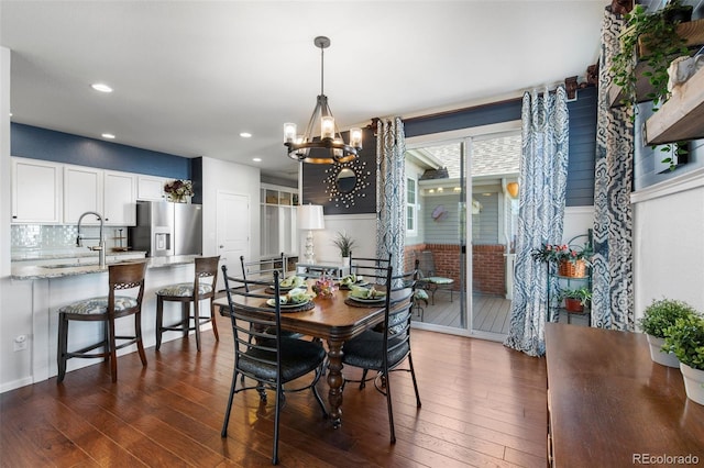 dining room with a chandelier, dark wood finished floors, and recessed lighting