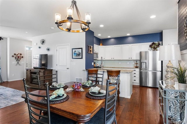 dining room featuring a chandelier, dark wood finished floors, recessed lighting, and baseboards