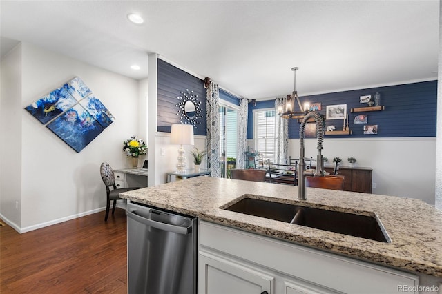 kitchen with dishwasher, a sink, a chandelier, light stone counters, and dark wood finished floors
