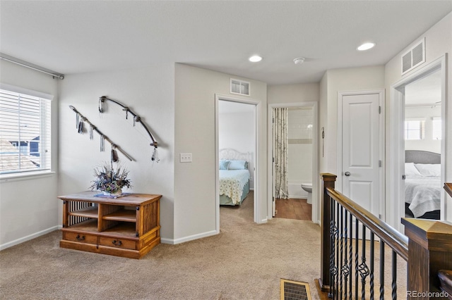 hall featuring carpet floors, an upstairs landing, recessed lighting, and baseboards