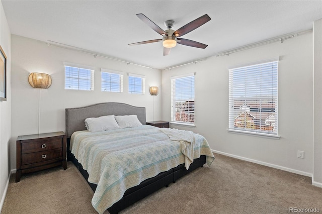 carpeted bedroom featuring baseboards and a ceiling fan