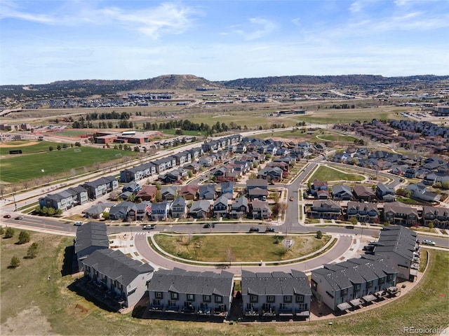 aerial view of property and surrounding area with a mountain backdrop and nearby suburban area