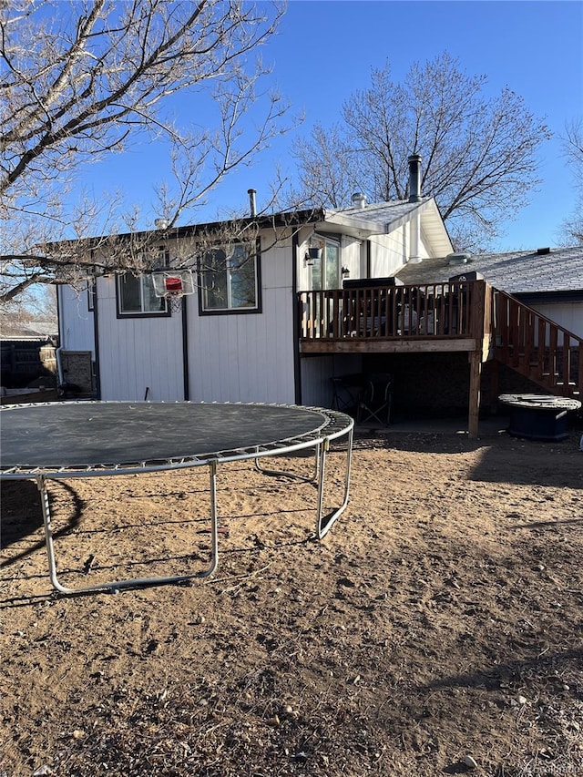 view of side of property featuring a deck and a trampoline