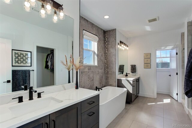 785 Delechant Dr, Erie, CO 80516 - bathroom featuring two vanities, tile patterned flooring, a soaking tub, a chandelier, and tiled shower