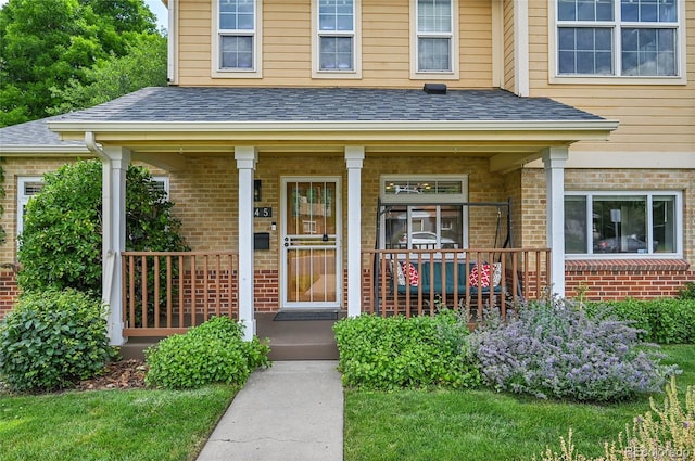 845 Jasmine St, Denver, CO 80220 - doorway to property with brick siding, a porch, and roof with shingles