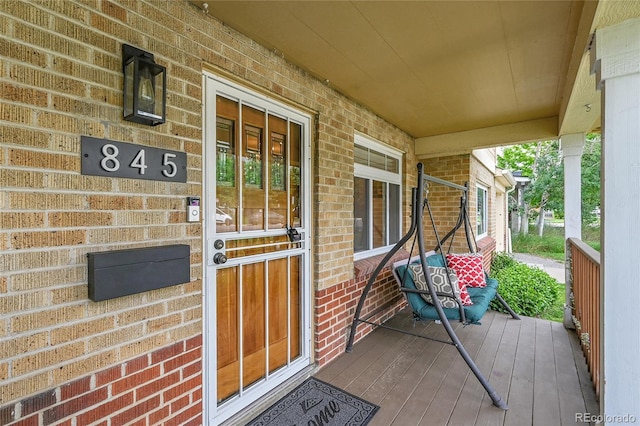845 Jasmine St, Denver, CO 80220 - doorway to property featuring brick siding and covered porch
