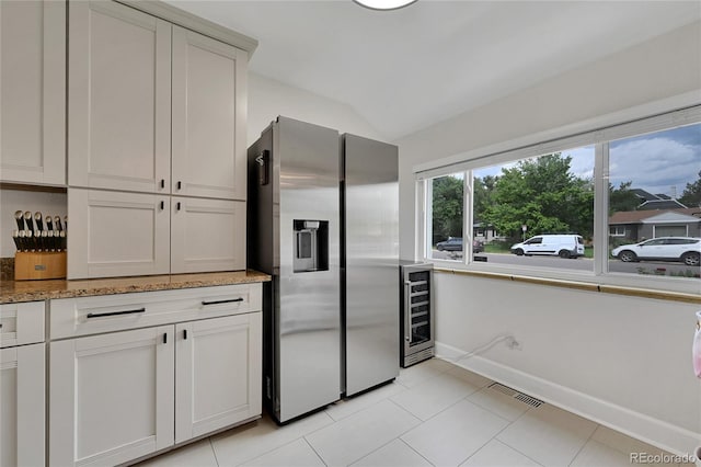 845 Jasmine St, Denver, CO 80220 - kitchen featuring stainless steel refrigerator with ice dispenser, beverage cooler, lofted ceiling, light stone counters, and light tile patterned floors