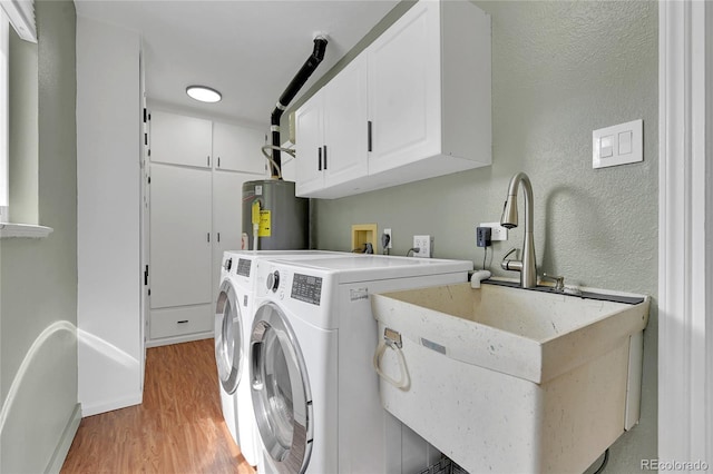 845 Jasmine St, Denver, CO 80220 - washroom featuring water heater, cabinet space, light wood-style floors, washer and dryer, and a textured wall