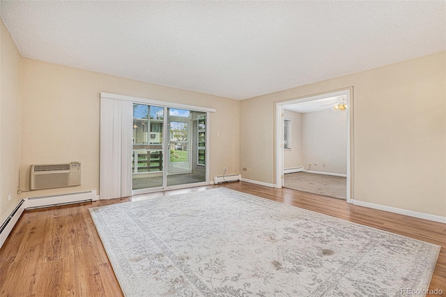 empty room with hardwood / wood-style flooring, a wall unit AC, ceiling fan, and a baseboard heating unit