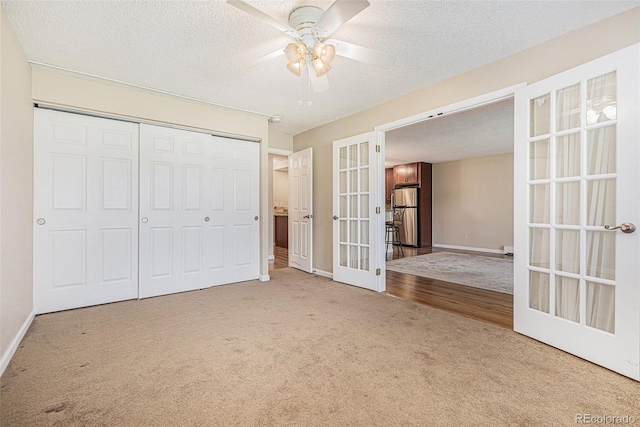 unfurnished bedroom featuring carpet, a closet, french doors, and ceiling fan