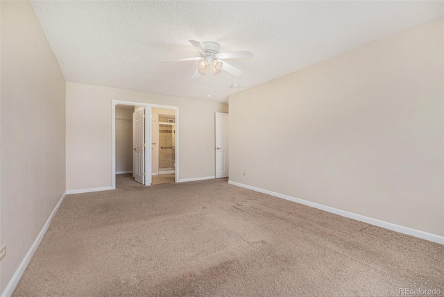 unfurnished bedroom featuring ceiling fan, light colored carpet, a spacious closet, and a closet