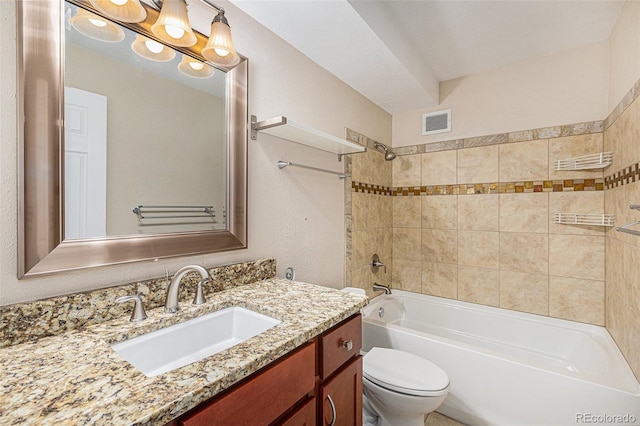 full bathroom featuring vanity, toilet, and tiled shower / bath