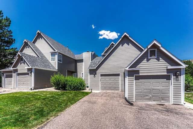 2028 Palm Dr, Colorado Springs, CO 80918 - traditional home with a garage, driveway, a shingled roof, and a front lawn