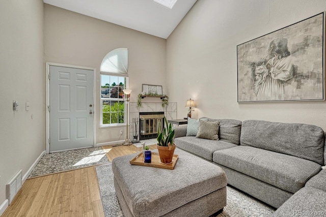 2028 Palm Dr, Colorado Springs, CO 80918 - living area with high vaulted ceiling, wood finished floors, and a tile fireplace