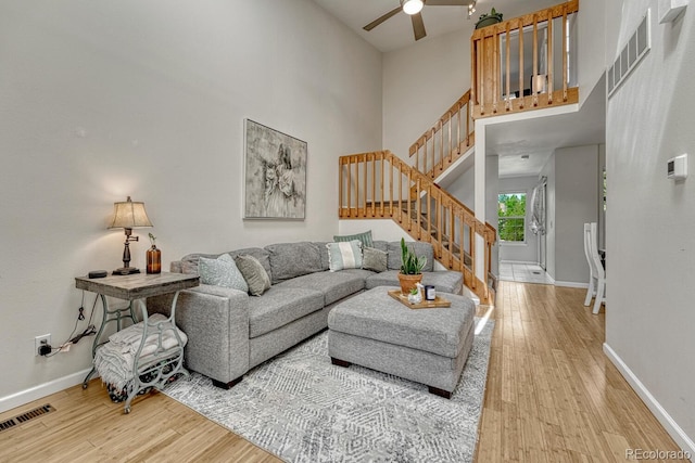 2028 Palm Dr, Colorado Springs, CO 80918 - living area featuring light wood-type flooring, a ceiling fan, a high ceiling, and stairs