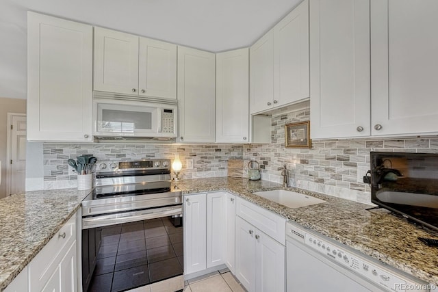 2028 Palm Dr, Colorado Springs, CO 80918 - kitchen featuring white appliances, light tile patterned floors, backsplash, white cabinets, and light stone countertops