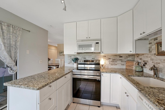 2028 Palm Dr, Colorado Springs, CO 80918 - kitchen featuring white appliances, backsplash, light stone countertops, and white cabinetry