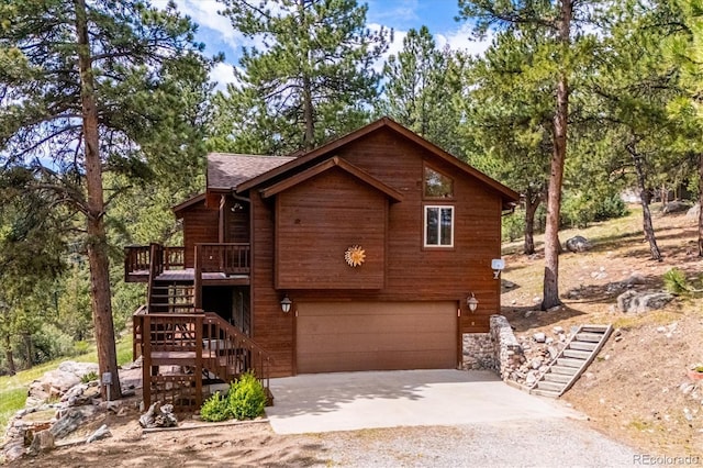 84 Sunny Ridge Ln, Bailey, CO 80421 - rustic home featuring stairs, concrete driveway, an attached garage, and a deck