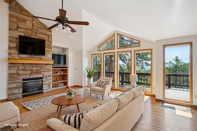 84 Sunny Ridge Ln, Bailey, CO 80421 - living area featuring lofted ceiling, wood finished floors, a ceiling fan, and a stone fireplace