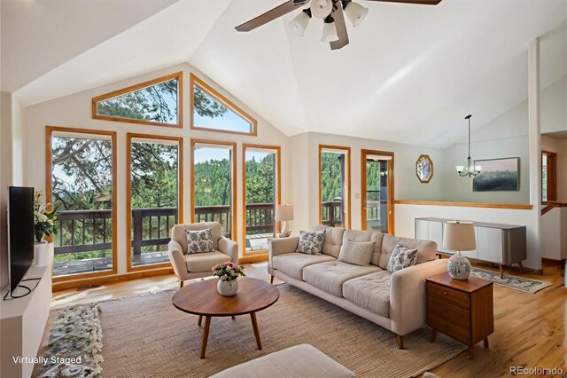 84 Sunny Ridge Ln, Bailey, CO 80421 - living area featuring lofted ceiling, wood finished floors, a chandelier, and healthy amount of natural light