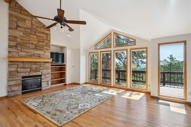 84 Sunny Ridge Ln, Bailey, CO 80421 - unfurnished living room featuring vaulted ceiling, ceiling fan, a stone fireplace, and wood finished floors