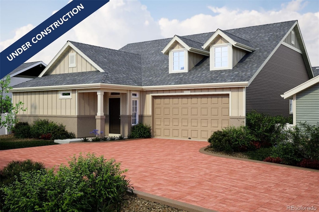 view of front facade with board and batten siding, decorative driveway, and an attached garage