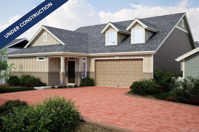 view of front facade with board and batten siding, decorative driveway, and an attached garage