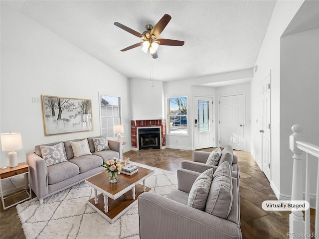 living room with ceiling fan and a fireplace