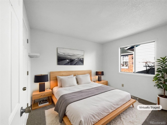 bedroom featuring carpet and a textured ceiling