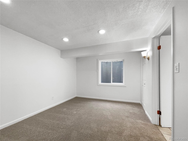 empty room with light colored carpet and a textured ceiling