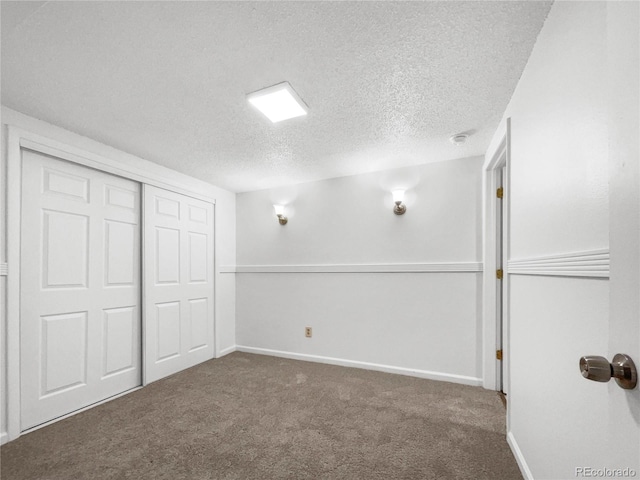 unfurnished bedroom with a closet, a textured ceiling, and dark colored carpet