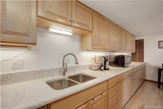 3675 S Cherokee St Unit 710, Englewood, CO 80110 - kitchen with a sink, stainless steel microwave, light brown cabinets, and light wood-style flooring