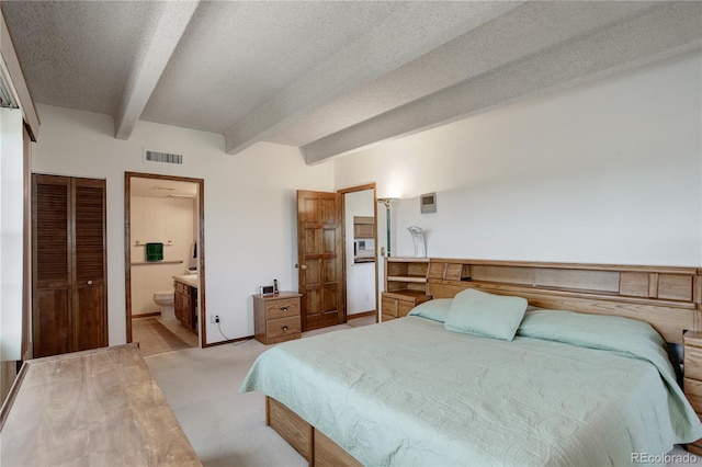 3675 S Cherokee St Unit 710, Englewood, CO 80110 - bedroom with beamed ceiling, light colored carpet, ensuite bath, a textured ceiling, and baseboards