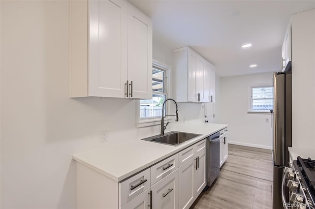 5090 Tejon St, Denver, CO 80221 - kitchen with a sink, stainless steel appliances, white cabinets, light countertops, and light wood-type flooring
