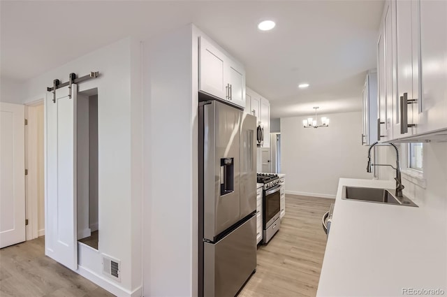 5090 Tejon St, Denver, CO 80221 - kitchen with appliances with stainless steel finishes, a sink, light wood finished floors, white cabinets, and recessed lighting