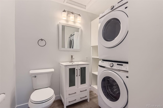 5090 Tejon St, Denver, CO 80221 - bathroom featuring estacked washer and dryer, toilet, wood finished floors, vanity, and baseboards